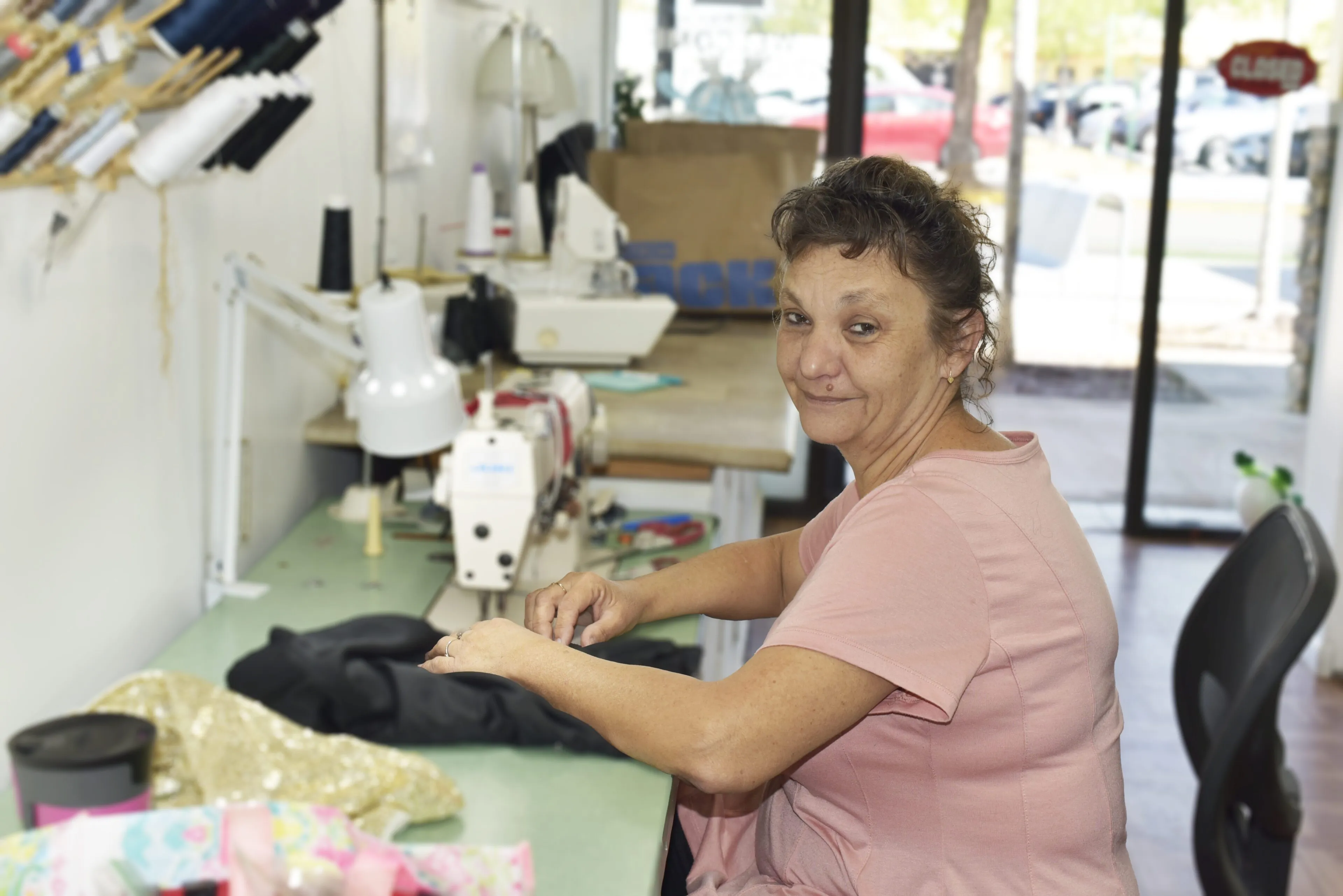 Erika, seamstress at JM Cleaners, tailoring a garment