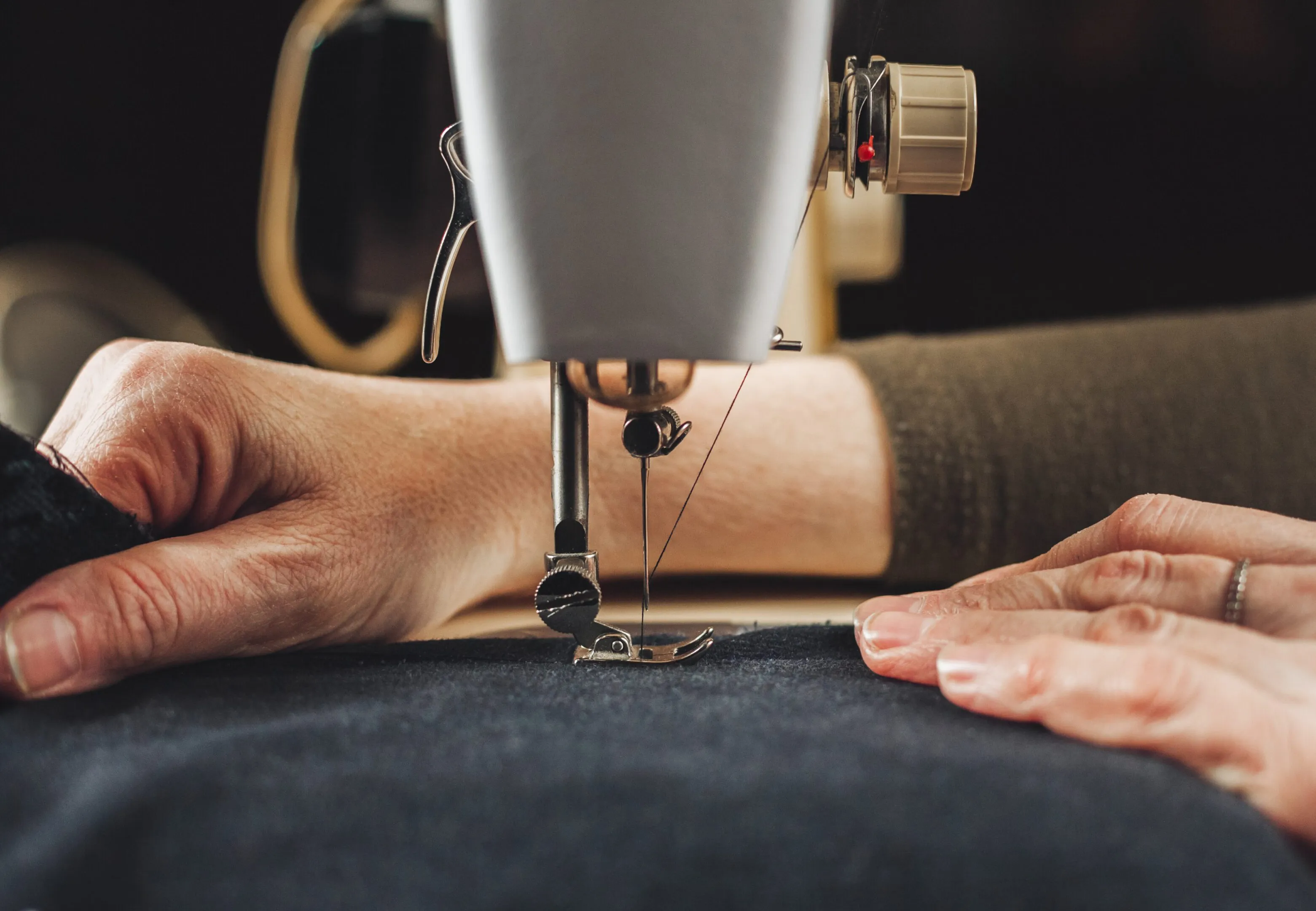 A seamstress guiding fabric through a sewing machine