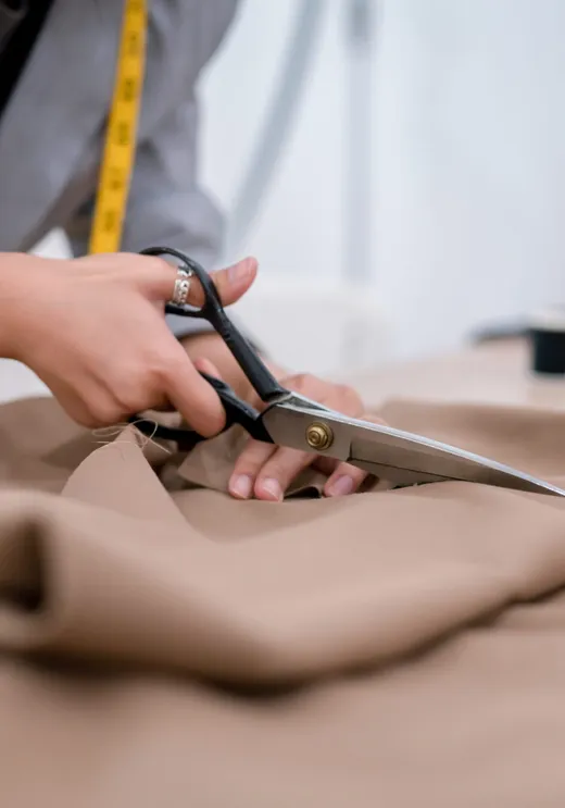 A tailor cutting and sewing fabric during a garment alteration