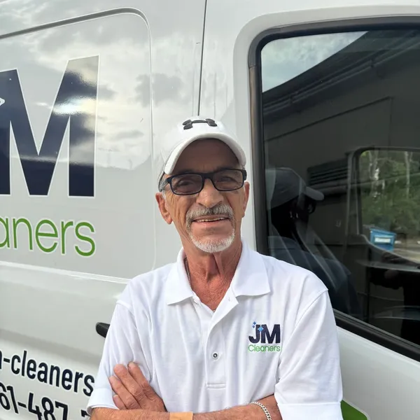 Dom, Pickup & Delivery Driver at JM Cleaners, in front of the JM Cleaners van
