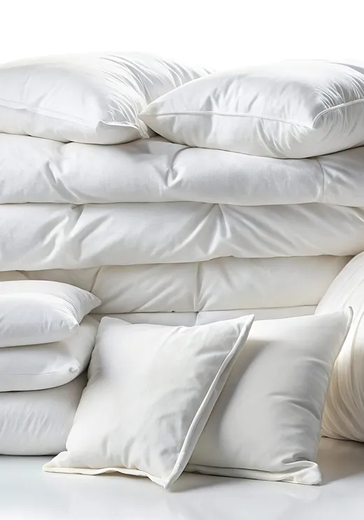 Neatly arranged white bedding, pillows, and a folded blanket
